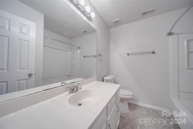 bathroom with a textured ceiling, toilet, and vanity