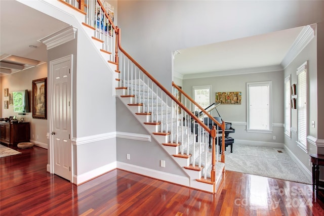 entryway with hardwood / wood-style floors and crown molding