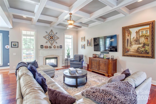 living room with ceiling fan, coffered ceiling, beamed ceiling, hardwood / wood-style flooring, and ornamental molding