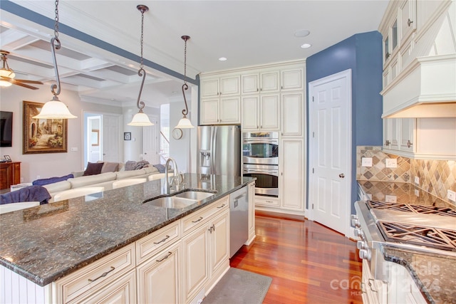 kitchen featuring a kitchen island with sink, coffered ceiling, sink, dark stone countertops, and beam ceiling