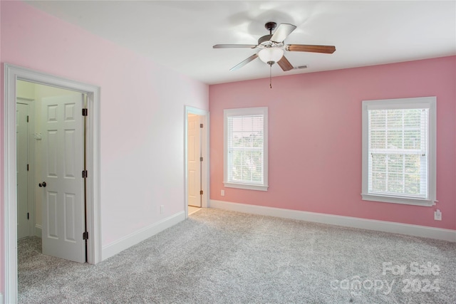 carpeted spare room featuring ceiling fan