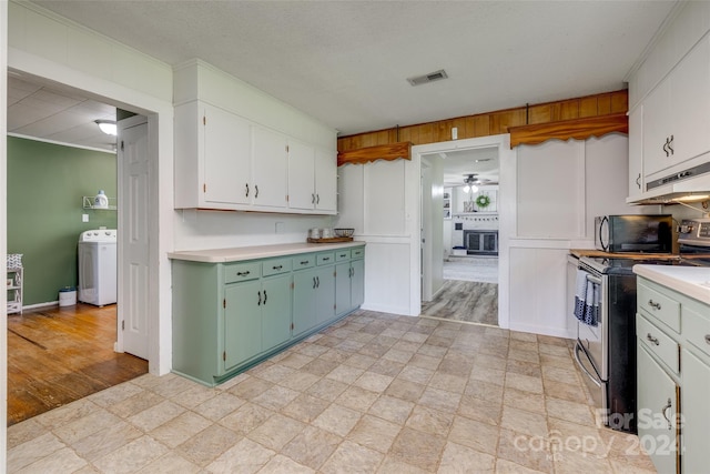 kitchen with washer / clothes dryer, white cabinetry, ceiling fan, and stainless steel range with electric stovetop