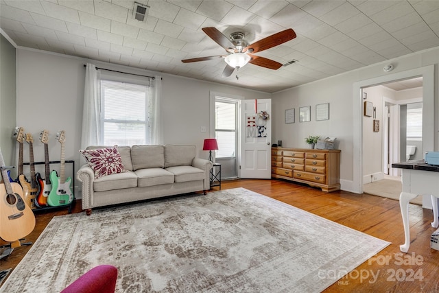 living room featuring ceiling fan, crown molding, and hardwood / wood-style flooring