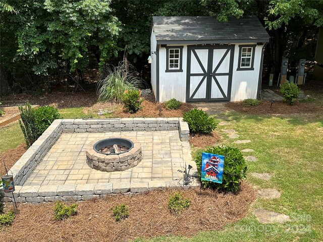 view of outdoor structure with a fire pit and a lawn