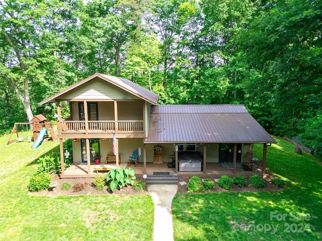 view of front of property featuring a front yard, a patio, and a playground