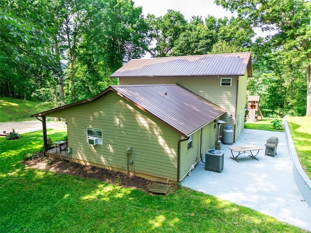 rear view of property with a lawn, cooling unit, and a patio