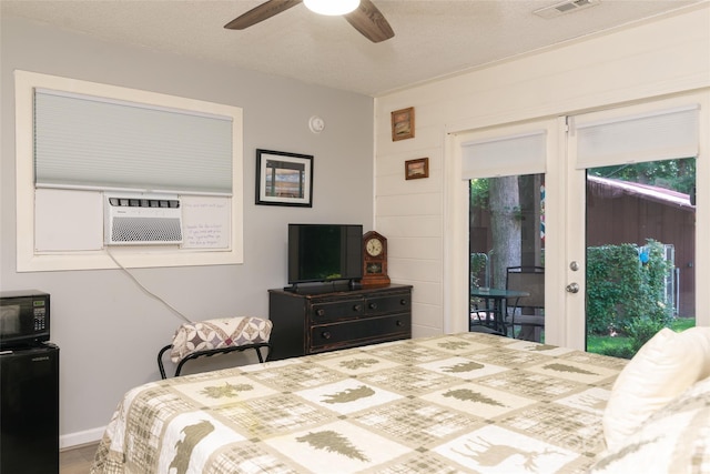 bedroom with access to exterior, ceiling fan, cooling unit, and a textured ceiling