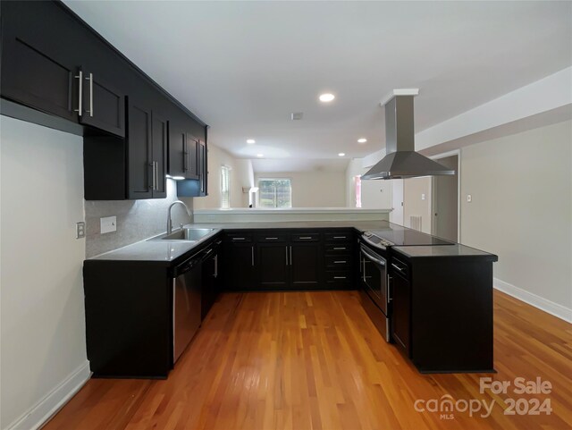 kitchen with light hardwood / wood-style flooring, kitchen peninsula, dishwasher, fume extractor, and electric stove