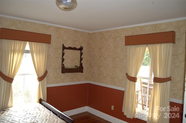 unfurnished bedroom featuring multiple windows, crown molding, and hardwood / wood-style floors