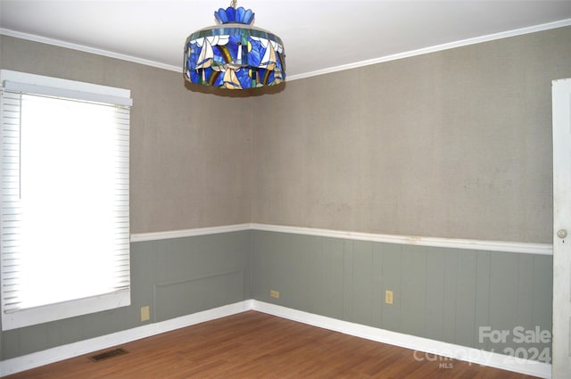 empty room with crown molding and hardwood / wood-style flooring