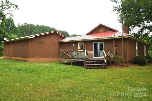 back of property with a yard and a wooden deck