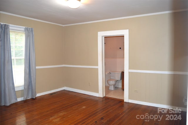 empty room with dark hardwood / wood-style flooring and crown molding