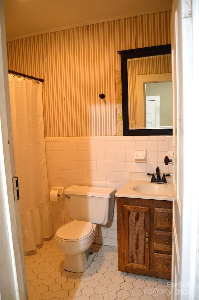 bathroom with tile patterned floors, vanity, toilet, and tile walls