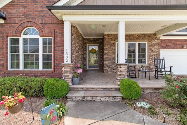 entrance to property with covered porch and a garage