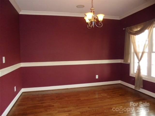 unfurnished dining area featuring baseboards, a chandelier, dark wood-type flooring, and ornamental molding