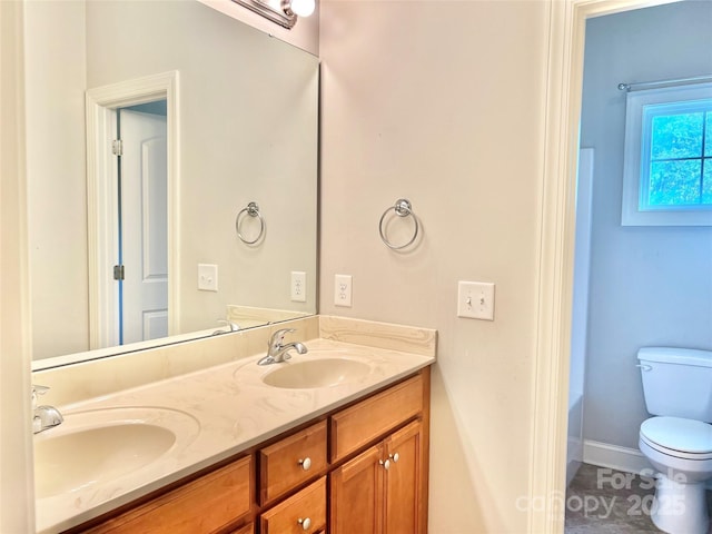 full bathroom with a tub, a sink, toilet, and double vanity