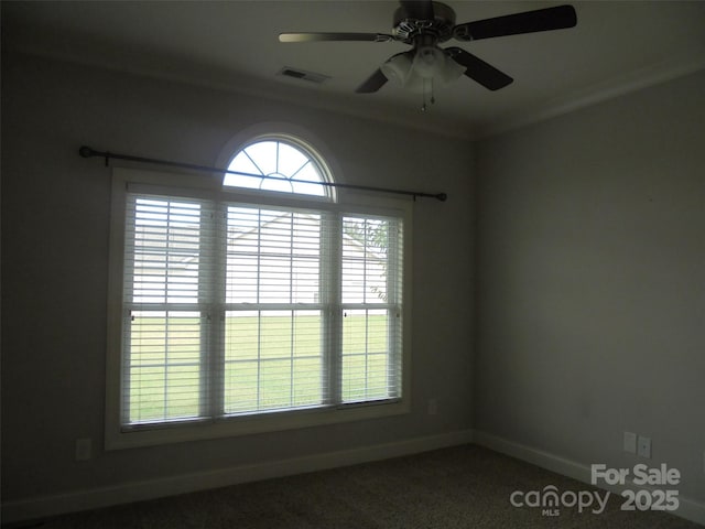 unfurnished room with baseboards, visible vents, ceiling fan, and crown molding