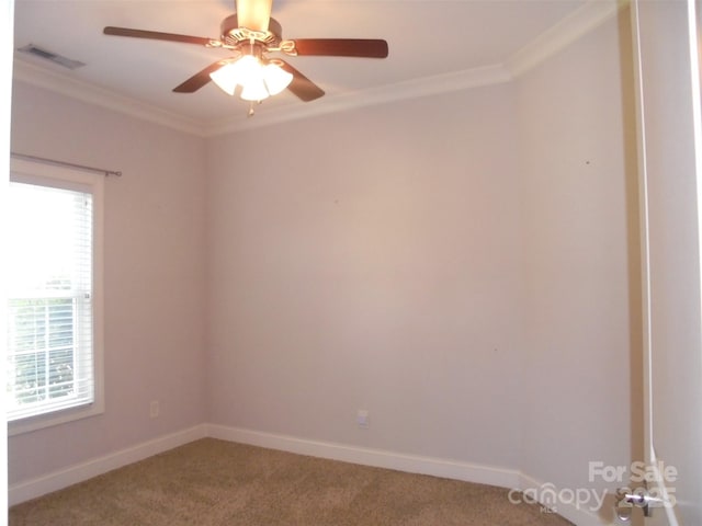 unfurnished room with ceiling fan, visible vents, baseboards, ornamental molding, and carpet