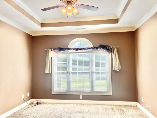 spare room featuring a raised ceiling, visible vents, crown molding, and carpet flooring