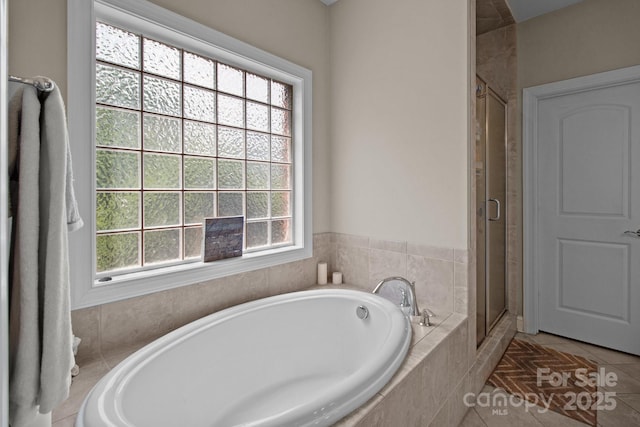 full bathroom with a shower stall, a bath, and tile patterned floors