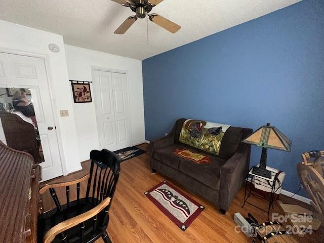 living room featuring wood-type flooring and ceiling fan