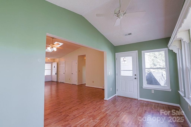 entrance foyer with a healthy amount of sunlight, visible vents, a ceiling fan, and lofted ceiling