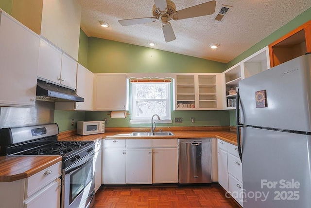 kitchen featuring under cabinet range hood, a sink, white cabinets, appliances with stainless steel finishes, and open shelves