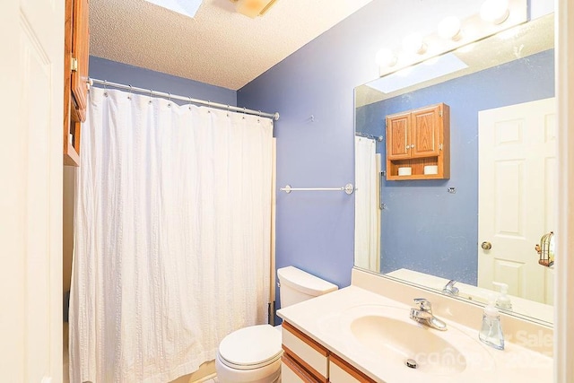 bathroom with a textured ceiling, toilet, and vanity