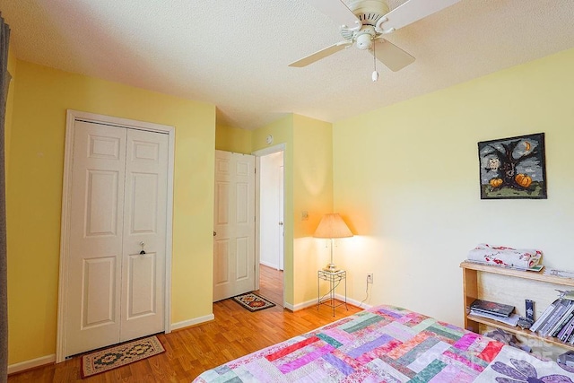 bedroom featuring a closet, light wood-type flooring, a ceiling fan, and baseboards