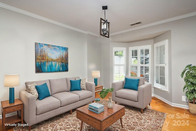 living room with ornamental molding, hardwood / wood-style flooring, and a chandelier