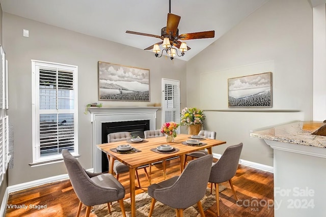 dining space with ceiling fan, dark wood-type flooring, and vaulted ceiling