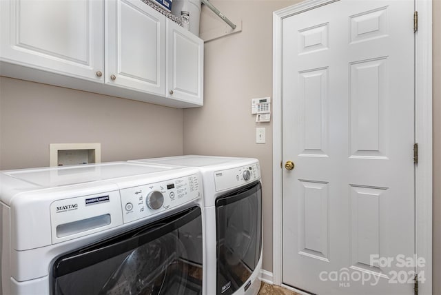 clothes washing area featuring cabinets and independent washer and dryer