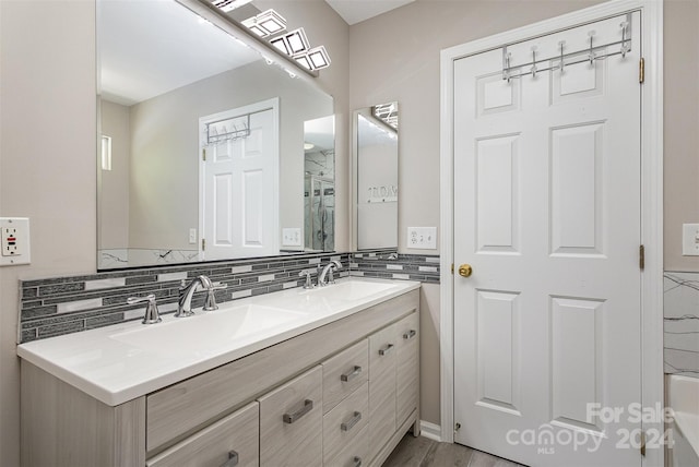 bathroom with vanity, hardwood / wood-style flooring, separate shower and tub, and backsplash