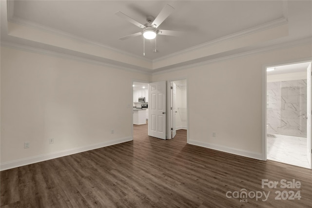 empty room featuring a raised ceiling, ceiling fan, and crown molding