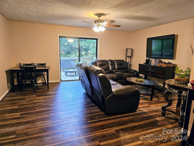 living room with ceiling fan, dark hardwood / wood-style flooring, and a textured ceiling