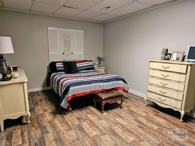 bedroom with hardwood / wood-style flooring and a drop ceiling