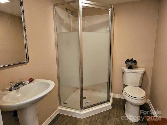 bathroom with wood-type flooring, toilet, and walk in shower