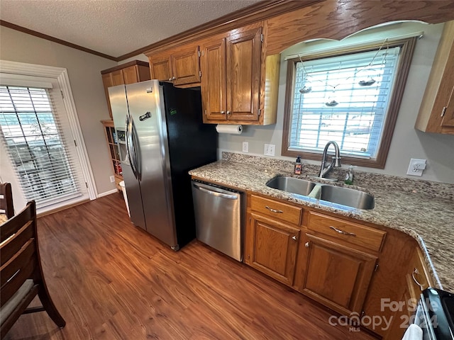 kitchen featuring sink, dark hardwood / wood-style floors, a textured ceiling, a wealth of natural light, and appliances with stainless steel finishes