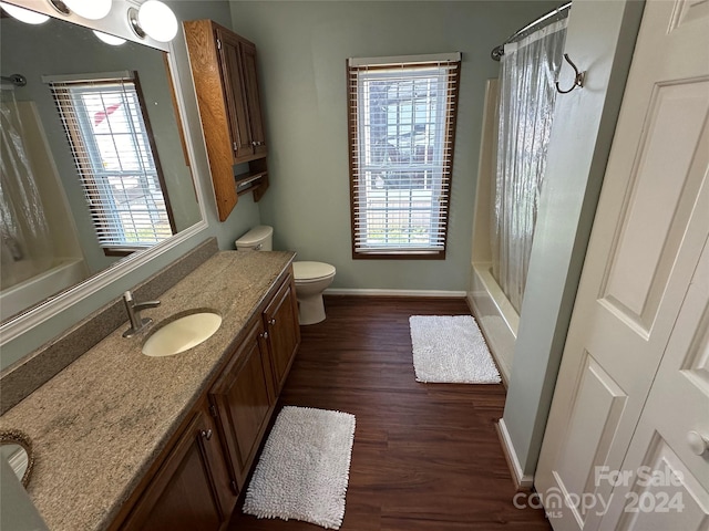 full bathroom featuring hardwood / wood-style floors, vanity, toilet, and shower / tub combo