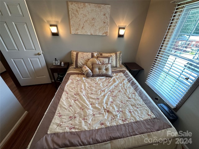 bedroom with dark hardwood / wood-style flooring