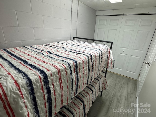 bedroom with wood-type flooring and a closet