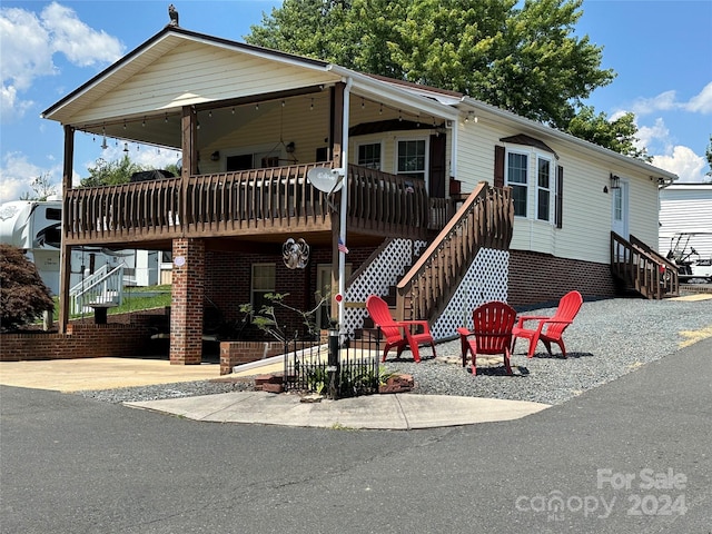 view of front of house featuring a wooden deck and a patio