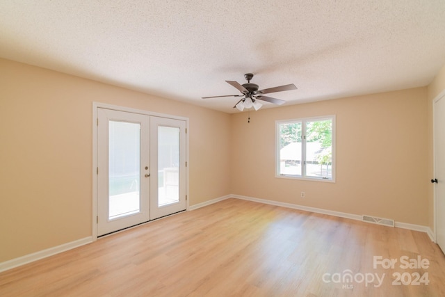 spare room with ceiling fan, french doors, a textured ceiling, and light hardwood / wood-style floors