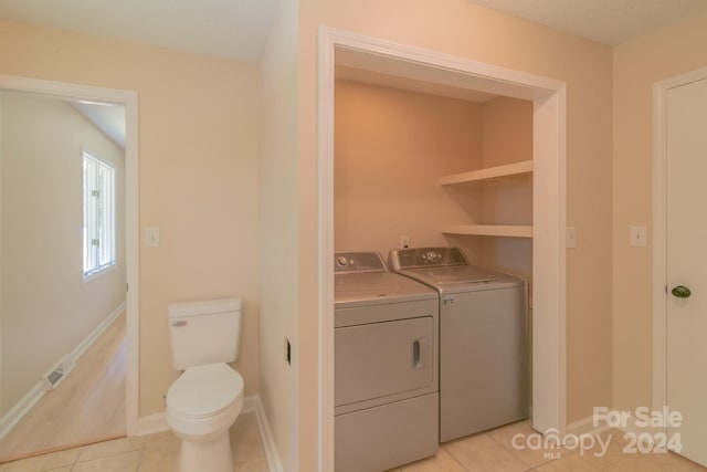 laundry area featuring light tile patterned floors and washer and dryer