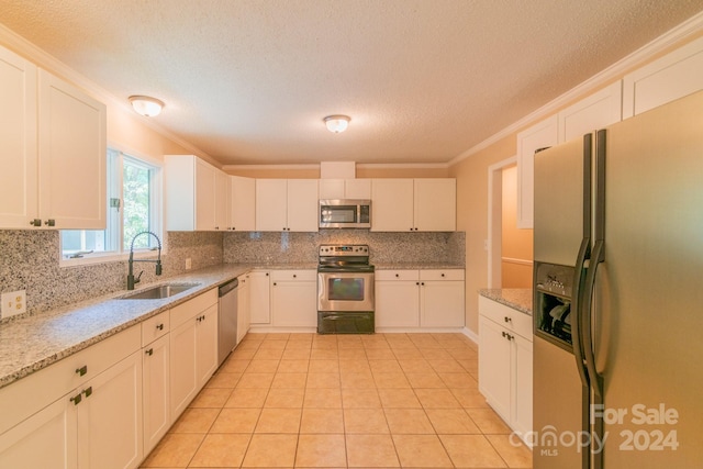 kitchen featuring white cabinetry, appliances with stainless steel finishes, light stone counters, and sink