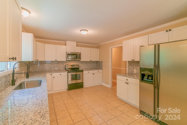 kitchen featuring light stone counters, sink, white cabinets, and appliances with stainless steel finishes