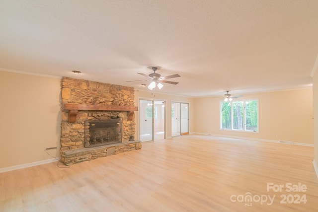 unfurnished living room with a healthy amount of sunlight, light wood-type flooring, crown molding, and a fireplace