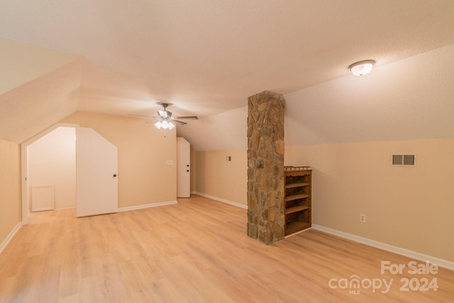 bonus room featuring ceiling fan, a textured ceiling, vaulted ceiling, and light wood-type flooring