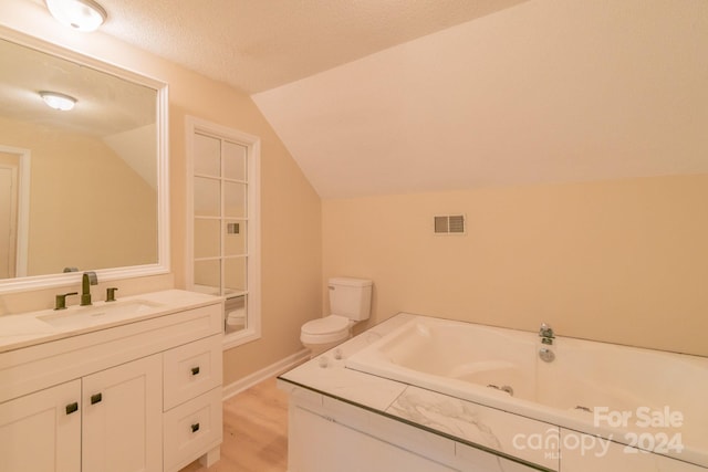 bathroom featuring toilet, hardwood / wood-style flooring, lofted ceiling, a textured ceiling, and vanity