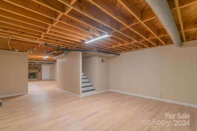 basement with a fireplace and hardwood / wood-style floors